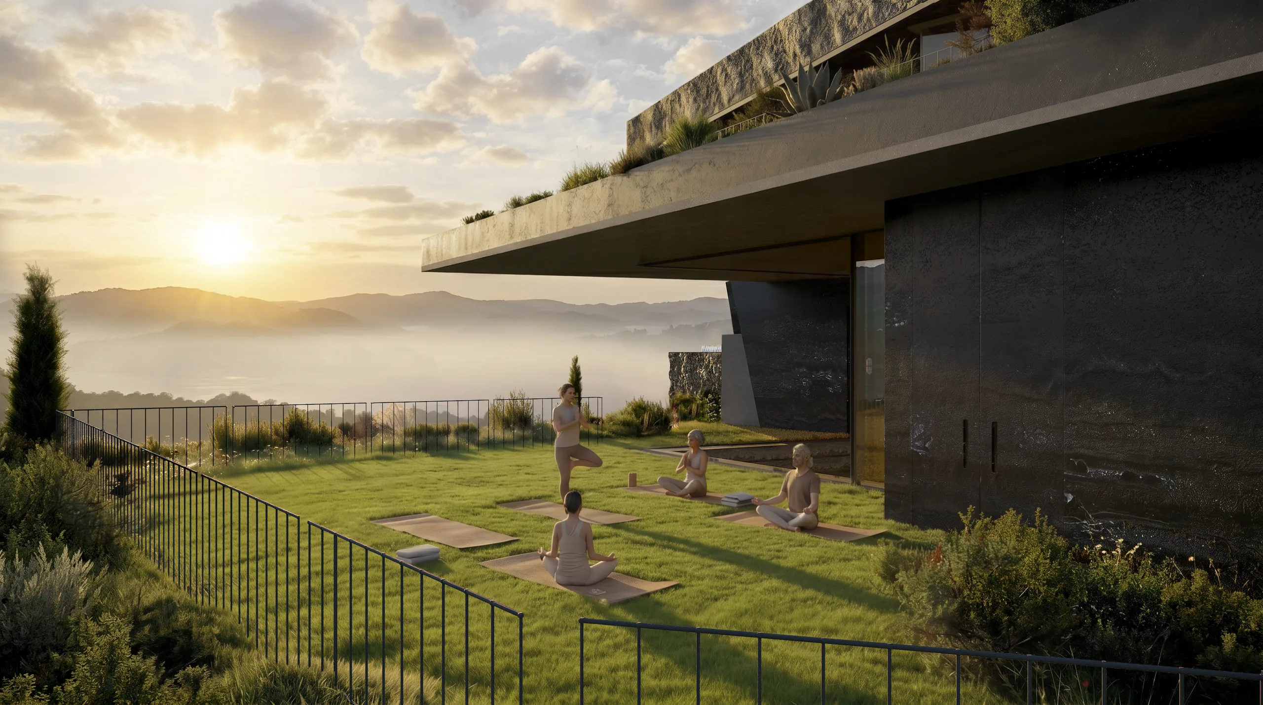 A residence terrace at sunset, sculptures on the lawn, the bay in mist.